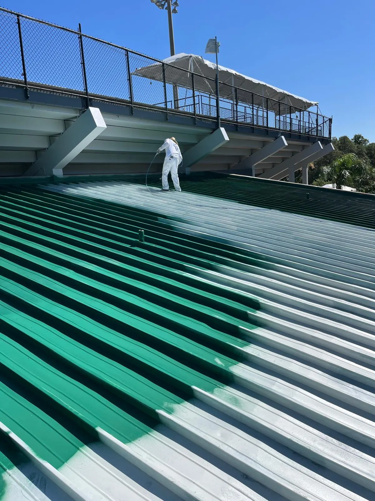 Stadium bleacher roof spray painting, close-up