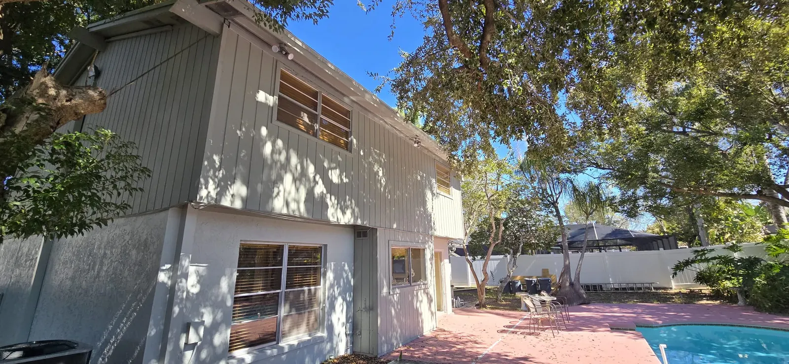 Residential exterior painting project near a backyard pool area